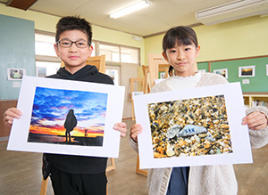 撮影した写真を手に北島さん㊧と山口さん