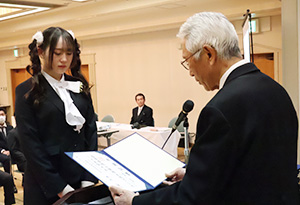 林校舎長㊨から卒業証書を受け取る生徒