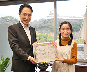 尾花市長に手作りの募金箱を手渡す浅利さん