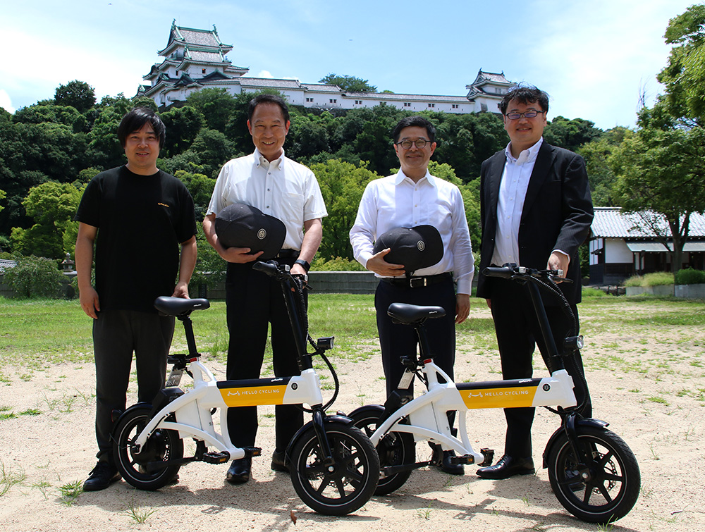 電動サイクルと（左から）鳴海社長、尾花市長、豊田社長、工藤社長