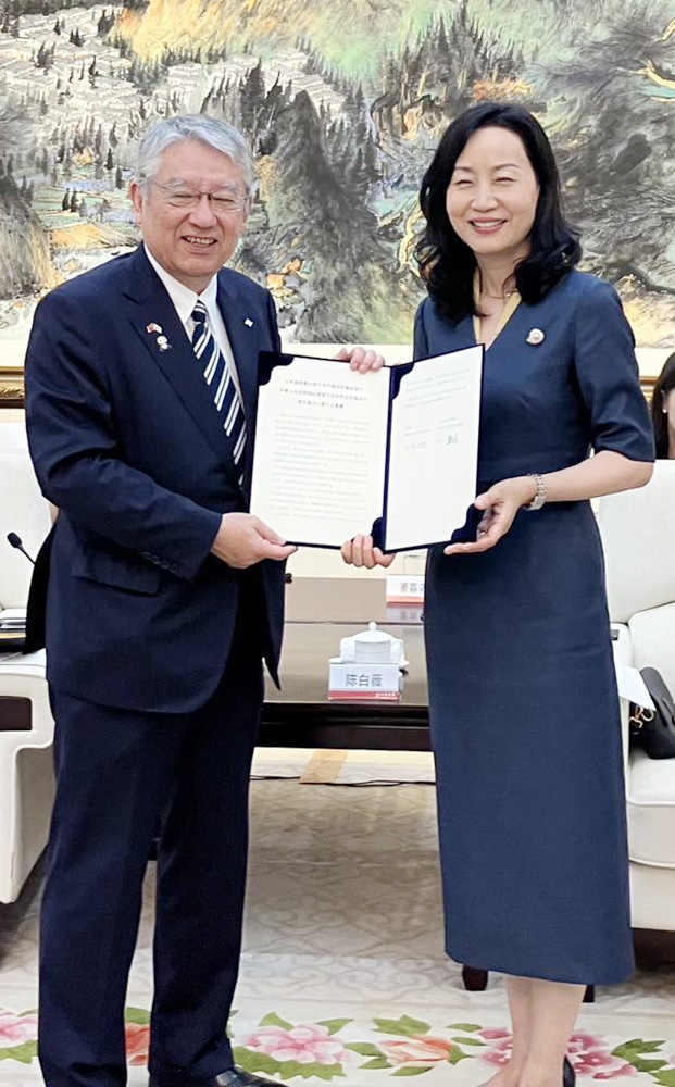 覚書を手にする中会長㊧と陳副会長（県日中友好協会提供）