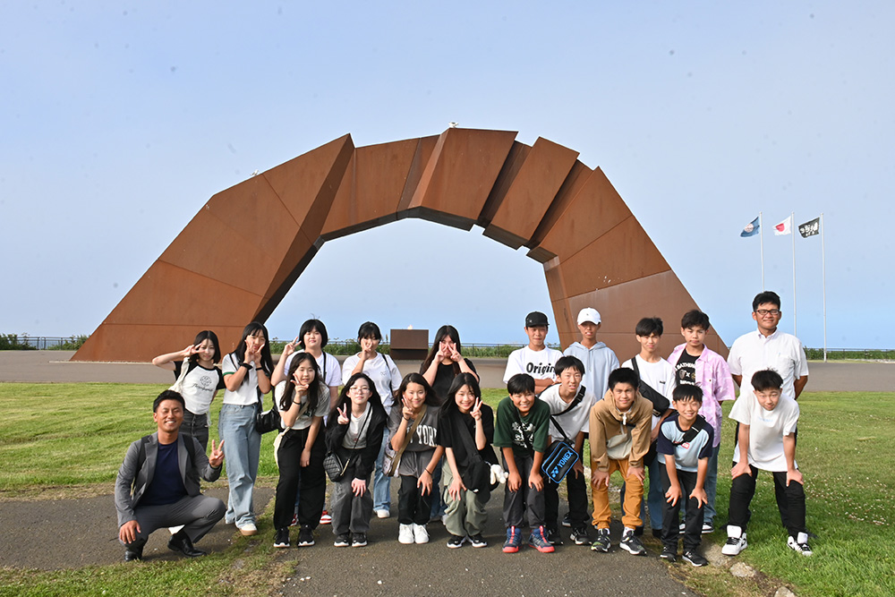 北方領土返還祈念シンボル像「四島のかけ橋」の前で研修に参加した中学生たち