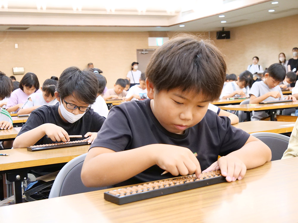 集中してそろばんをはじく参加者