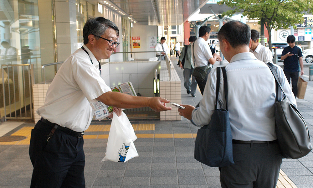 駅の利用者に啓発品を手渡して呼びかけた