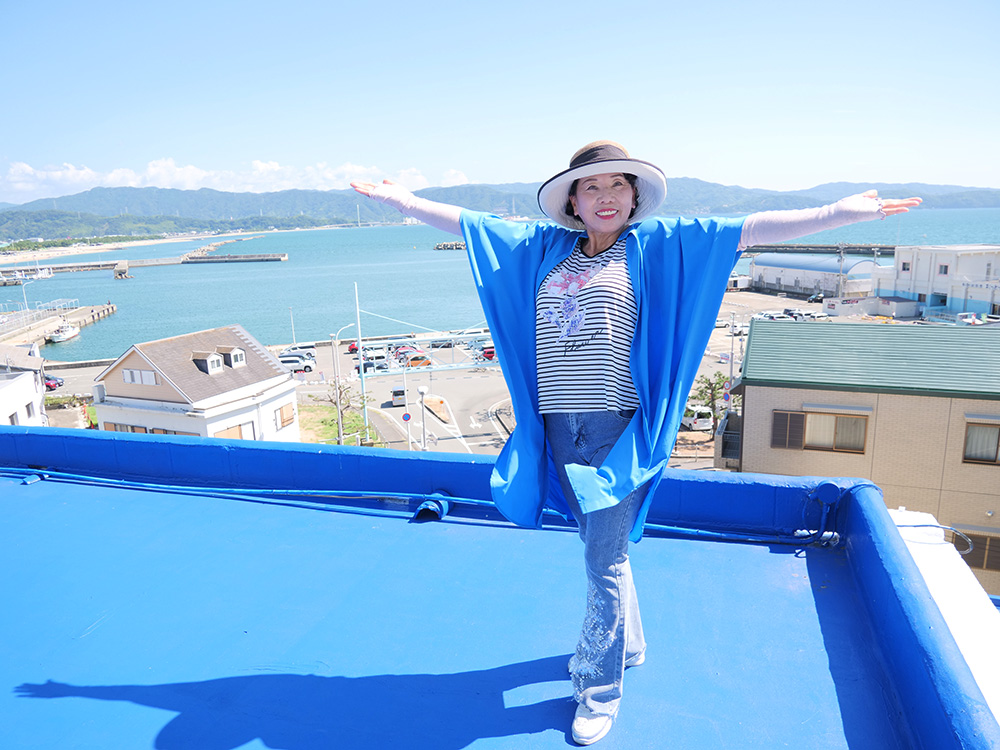 アパートの屋上で海風を浴びる鈴木さん