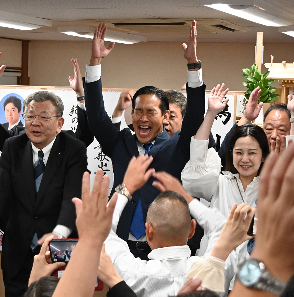 初当選を果たし万歳する山本さん（２８日午前１時８分）