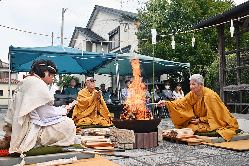 護摩木をくべて祈願する酒井住職㊥