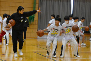 体を押し合いながらドリブルする練習を指導する内海コーチ㊧