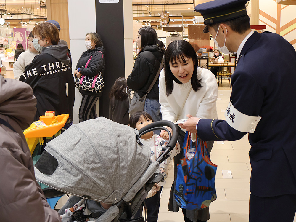 啓発グッズを受け取る親子連れ