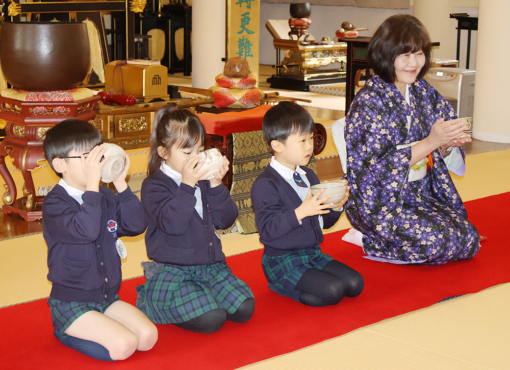 抹茶を味わう園児らと瀧本さん㊨