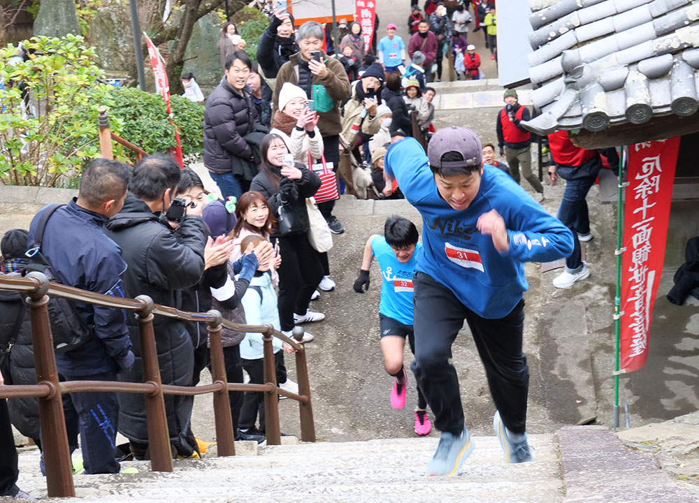 声援を受けながら石段を駆け上がる参加者