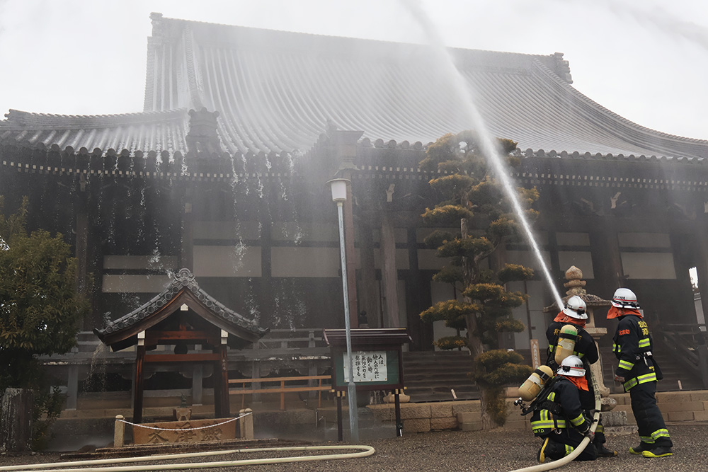 本堂に放水する消防隊員