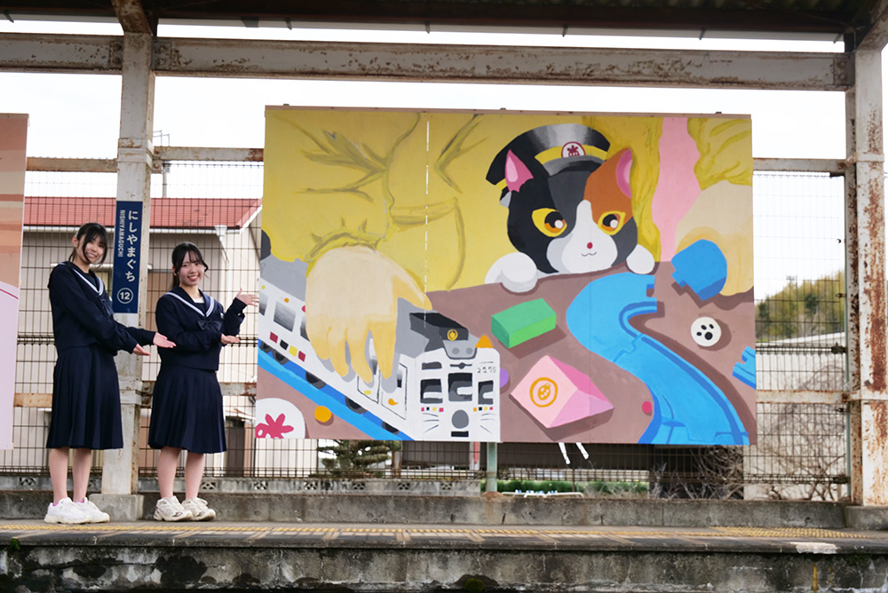 作品の横で笑顔の貴志川中・小西さん㊧と北山さん