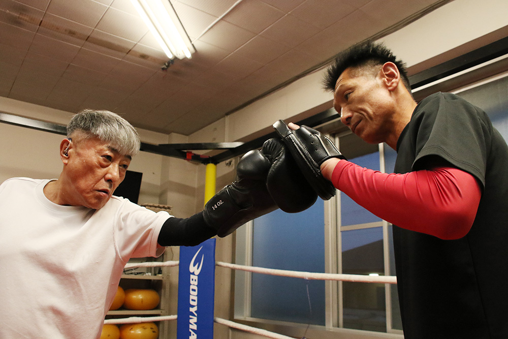 田村代表㊨とミット打ちの練習をする北畑さん