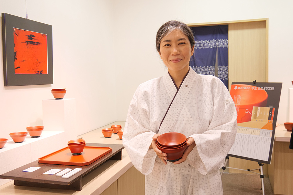 作品を手に笑顔の松江さん