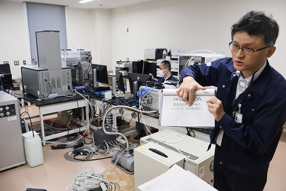 報道陣に新たに導入したPFASを測定する最新の機器を紹介する職員