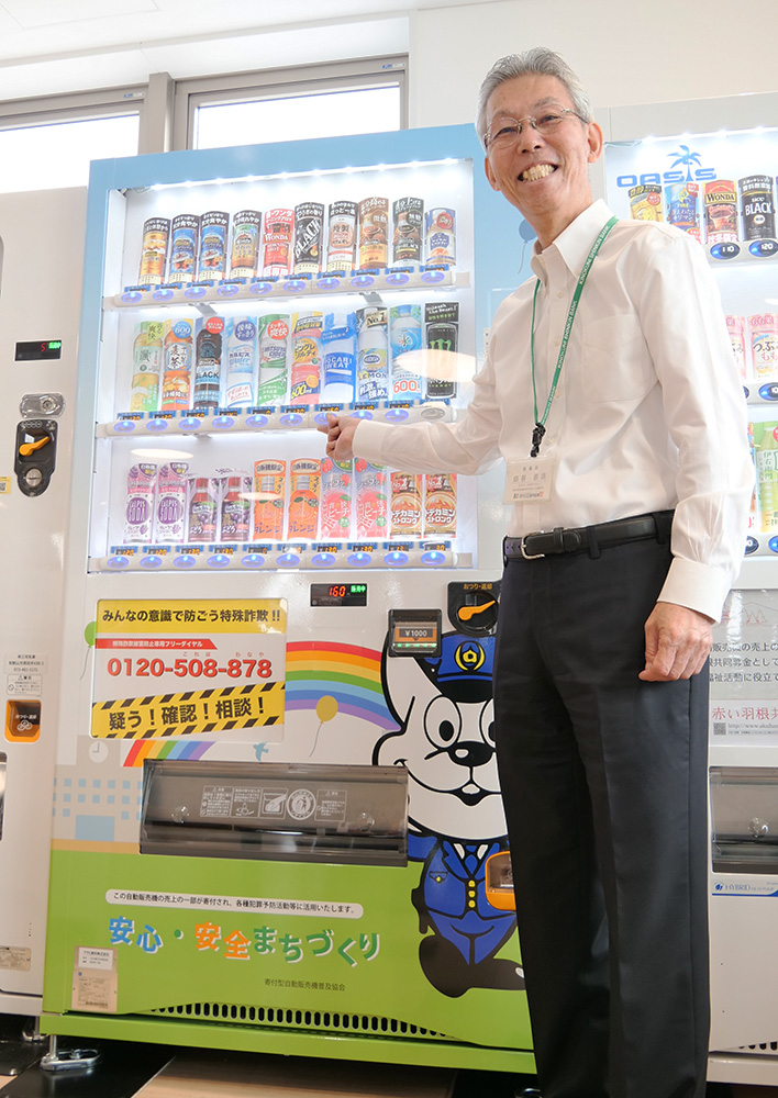 設置した自販機でドリンクを購入する田谷理事長