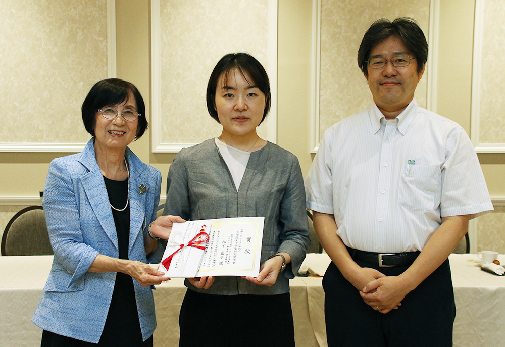 大学院女子学生研究奨学金を受けた松下さん㊥と須佐会長㊧、佐久間教授