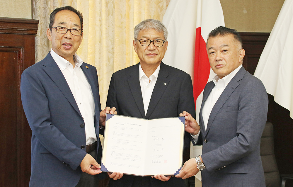 協定書を手に(左から)本山学長、宮﨑知事、内村専務執行役員