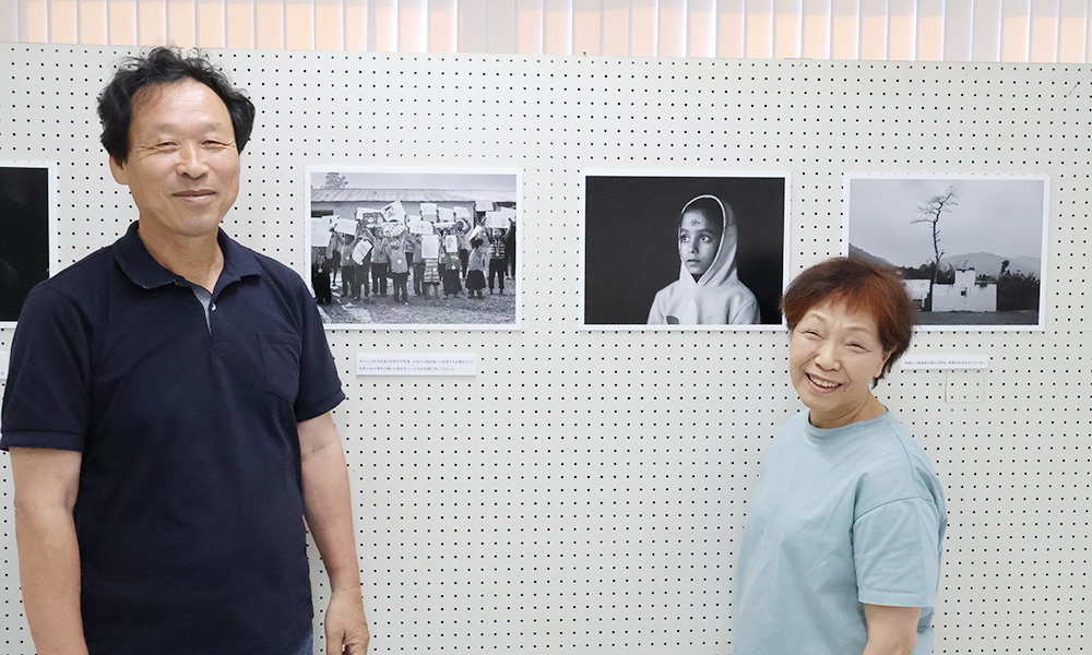 ネパールの子どもたちの様子を伝える写真の前で、岡田さん㊧と前田さん