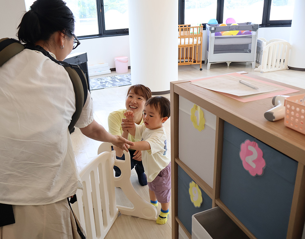 子どもを迎える山尾さん(中央)