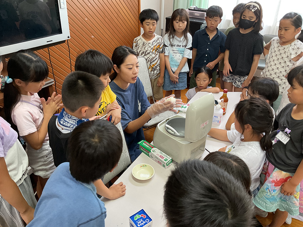 松尾店長から握り方を学ぶ児童ら(有功東小学校提供)