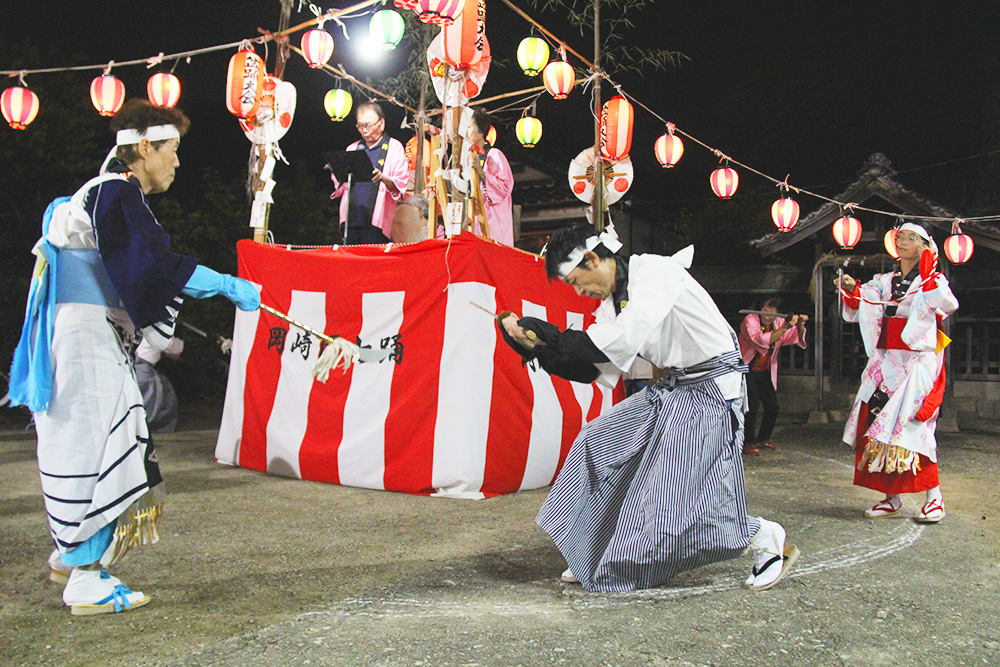 3人一組で踊る住民ら