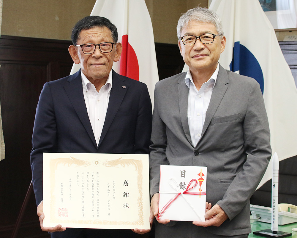 感謝状と目録を手にする小池代表取締役㊧、宮﨑知事