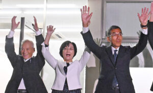 万歳で当選を喜ぶ小川さん㊨（８月３１日午後９時１７分ごろ）
