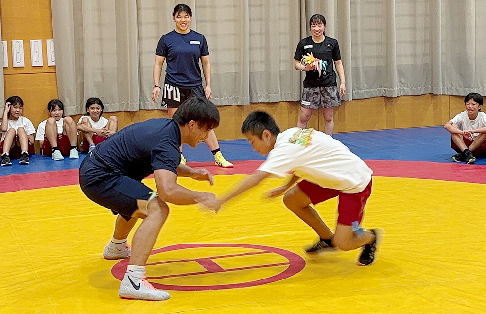 レスリングを指導する１期生の吉田さん㊧（県提供）