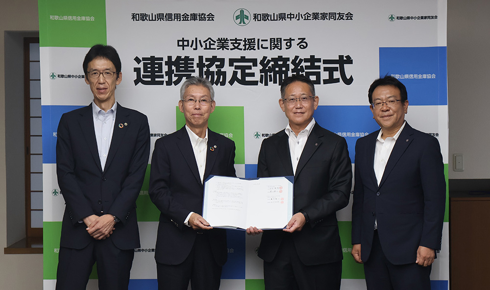 締結書を手に田谷会長（左から２人目）と熊井代表理事（同３人目）ら