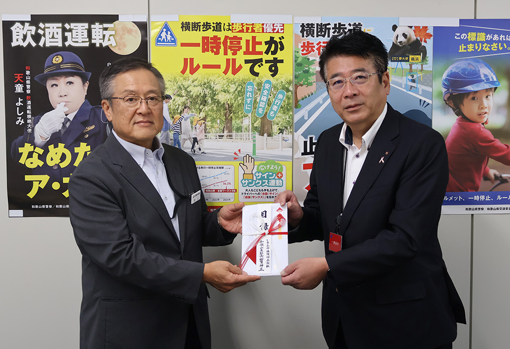 加賀支店長㊨が西川専務理事に目録を手渡した