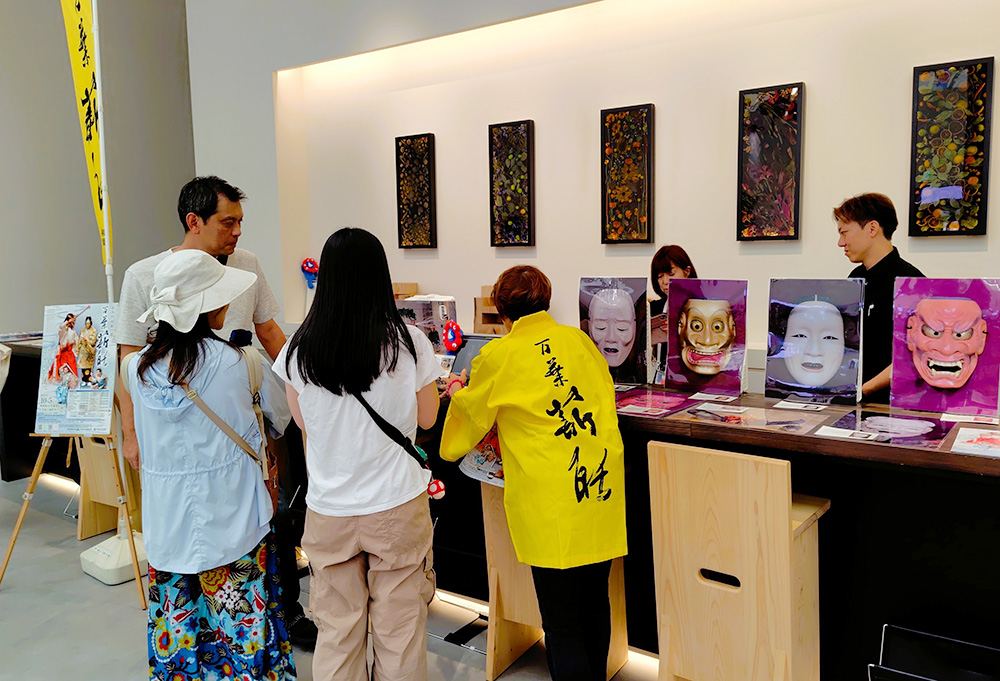 紹介展示を熱心に見る来場者（和歌の浦万葉薪能の会提供）