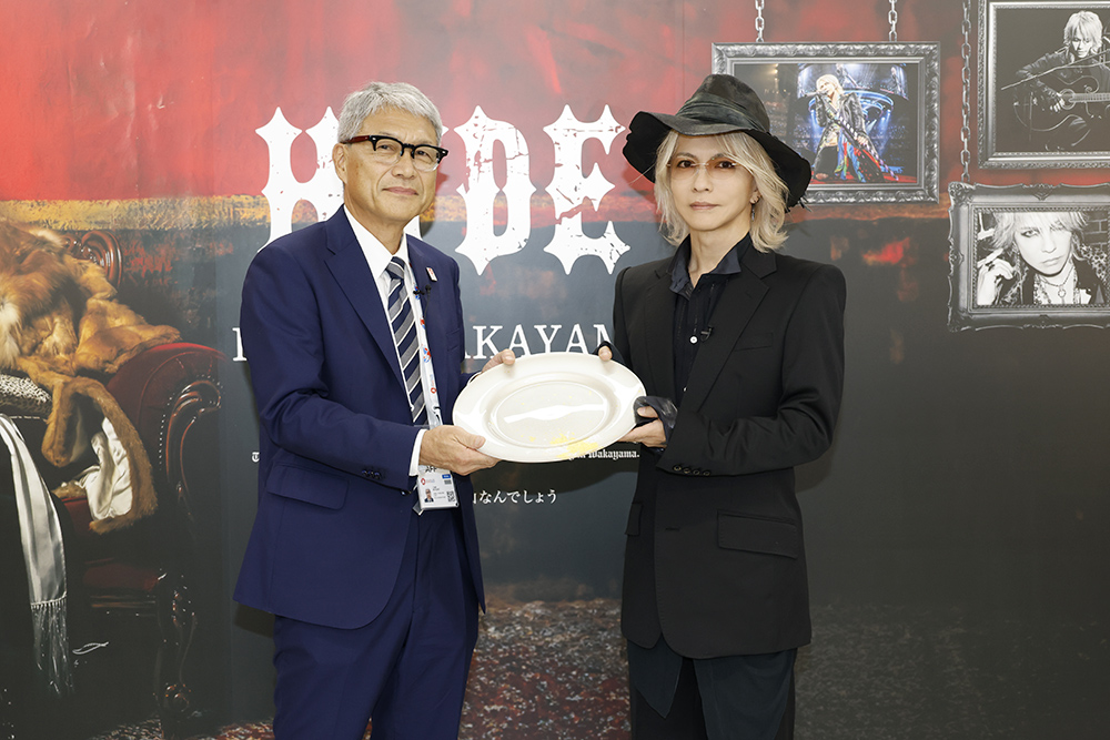 宮﨑知事㊧から贈り物を受け取るHYDEさん(田中和子撮影、県提供)