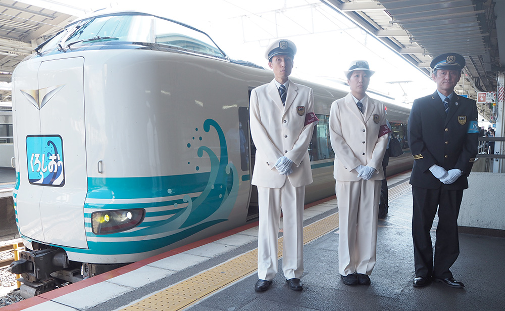 ラッピング列車と記念制服を着た車掌ら