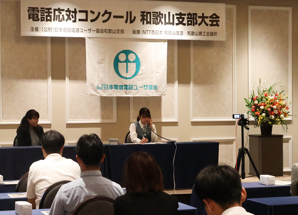 緊張感の中で電話応対する出場者