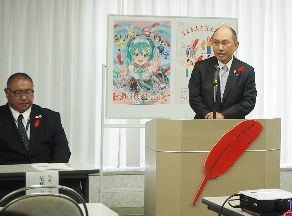あいさつをする大桑会長㊨