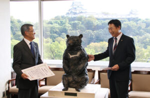 ベニーの等身大模型を見ながら歓談する前嶋会長㊧と尾花市長