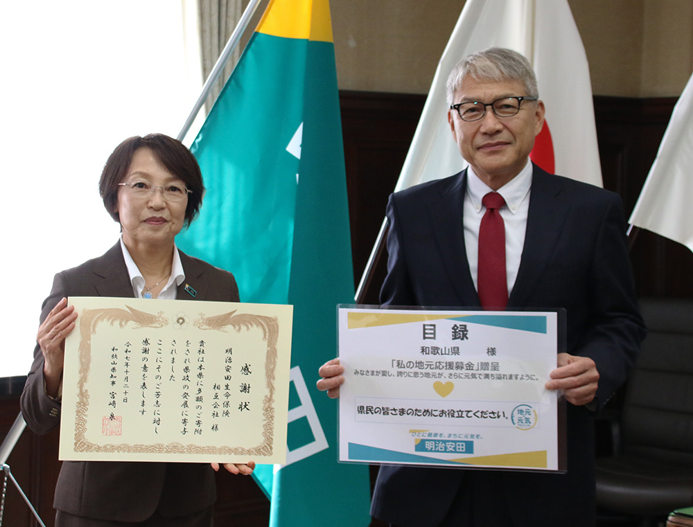 感謝状を手にする長谷川執行役員㊧、目録を手にする宮﨑知事