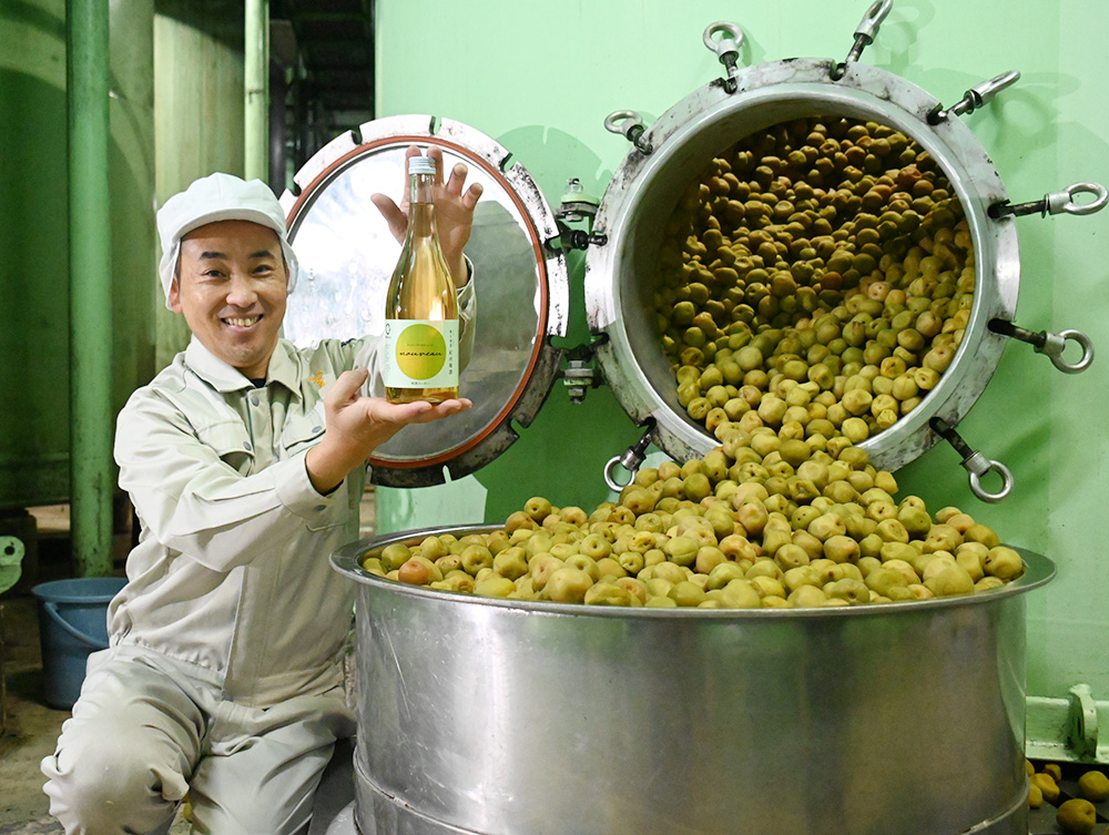梅酒ヌーボーを手に笑顔の藤原杜氏