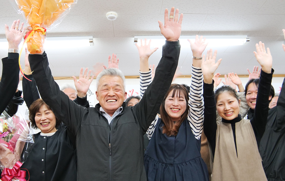支援者と万歳で喜びを分かち合う上岡さん