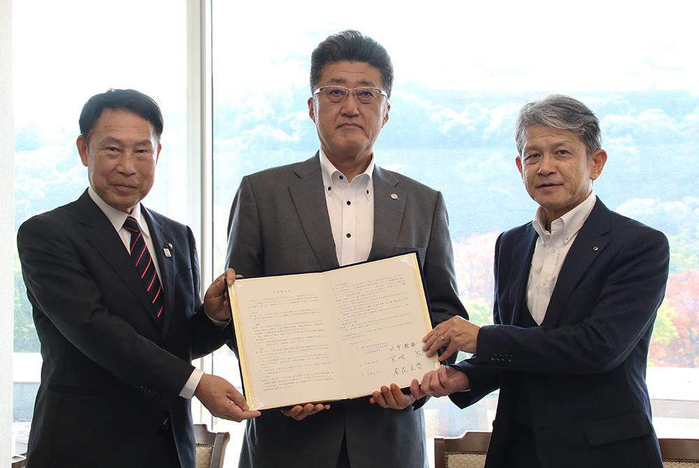 協定書を手に(左から)尾花市長、田中社長、中場部長