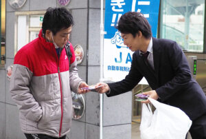 通行人にチラシを配布する関係者