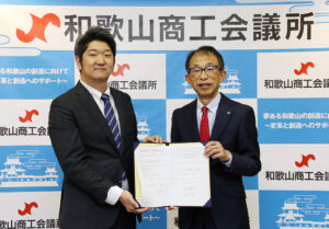 協定書を手にする田中専務理事㊨、石橋執行役員