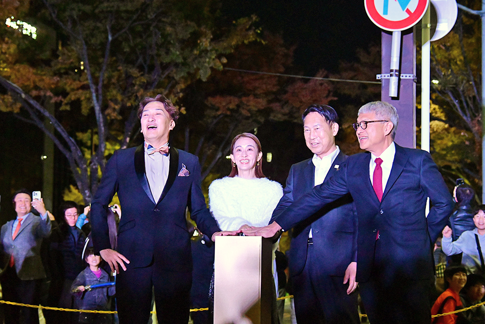 点灯ボタンを押す田中さん(左から2人目)ら