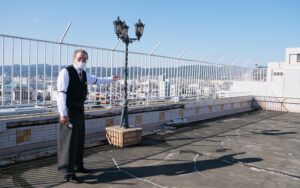 撮影場所近くのテラスを紹介する北田支配人