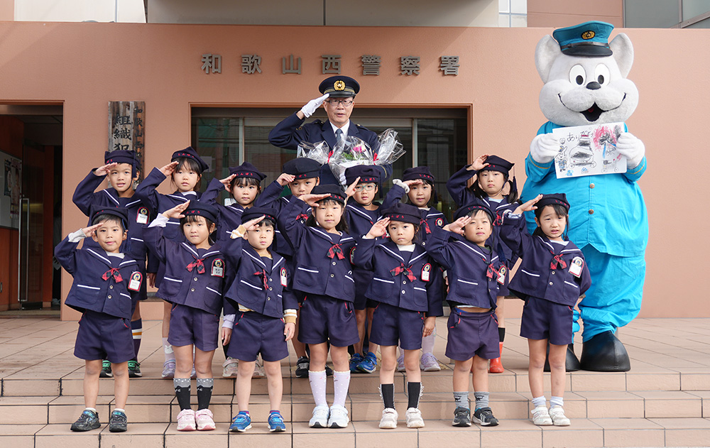 西署前で敬礼をする園児と津田署長