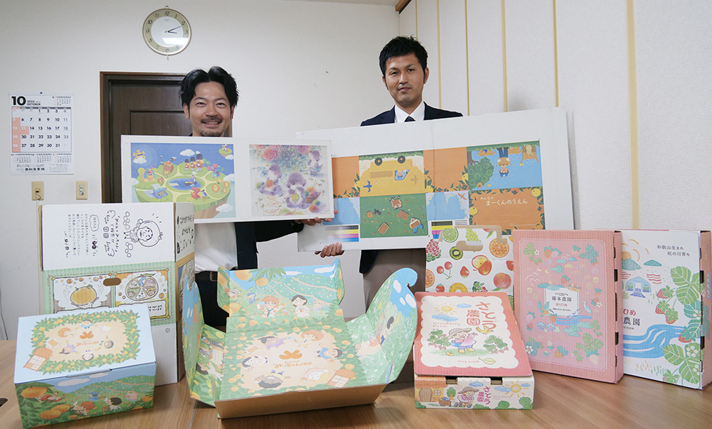 色鮮やかな段ボールを紹介する前垣部長㊧と西山康成営業係長