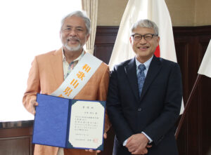 委嘱状を手に笑顔の小西さん㊧と宮﨑知事