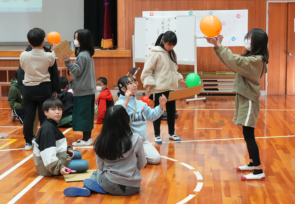 グループで話し合いながら実験する児童